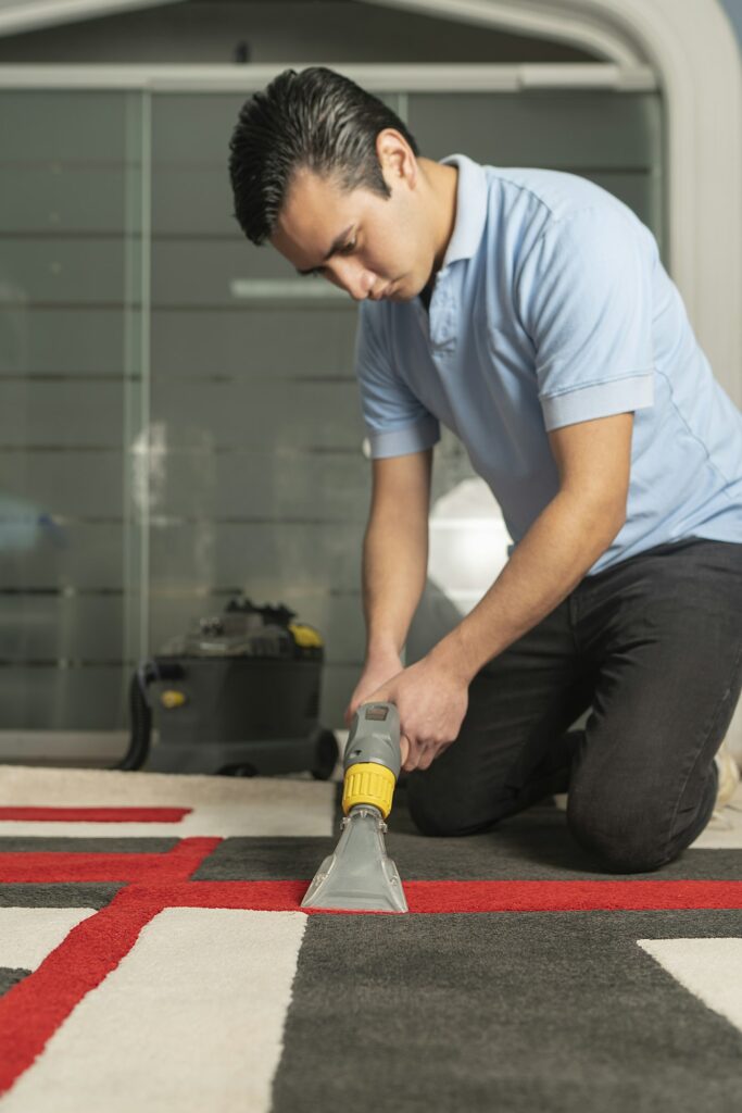 Technician cleaning an area rug with an extraction tool